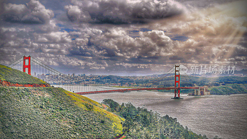 阳光在下雨天冲破金门大桥上的乌云。旧金山湾区背景•Gonzelman Road, Marin Highlands, San Francisco, CA, USA